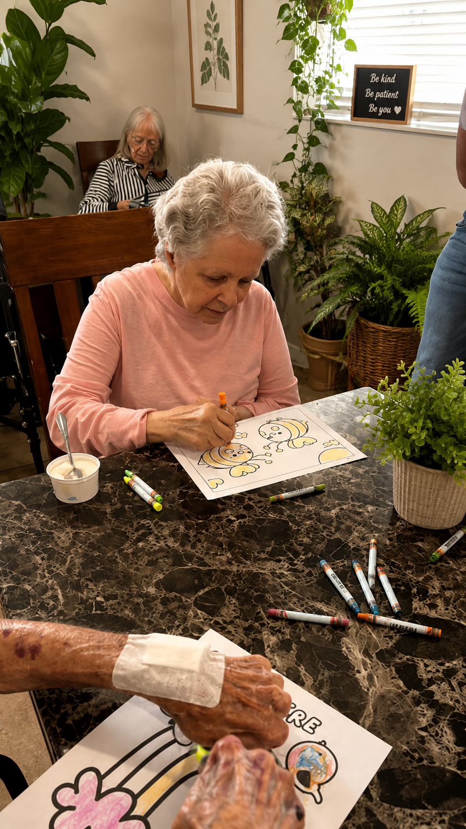 A resident focused on coloring a bee illustration during an art activity at Atlantis Senior Care Residence